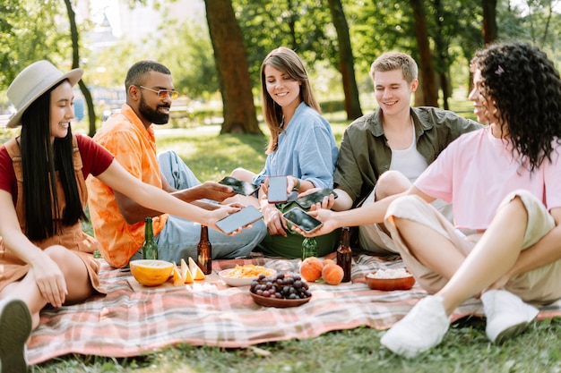 Gelukkige mensen die informatie uitwisselen op hun smartphones voor sociale media in het stadspark