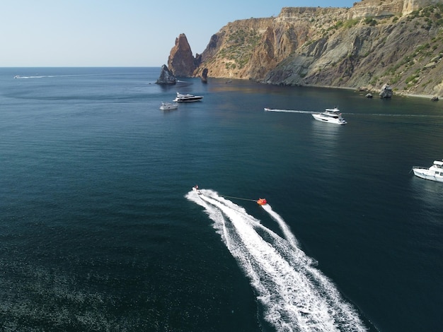 Gelukkige mensen gaan zwemmen op een luchtbed achter een jetski, toeristen rijden op het springkussen