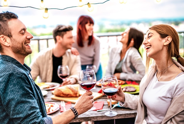 Gelukkige mensen plezier drinken van wijn op terras bij privé diner