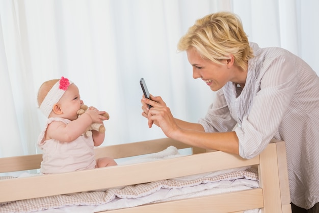 Gelukkige moeder die een beeld van haar babymeisje neemt