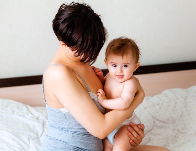 Gelukkige moeder die haar baby vasthoudt. moeder kust haar baby