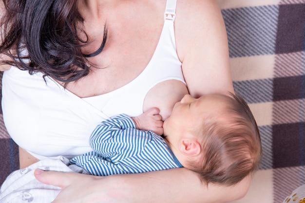 Gelukkige moeder die haar pasgeboren baby de borst geeft