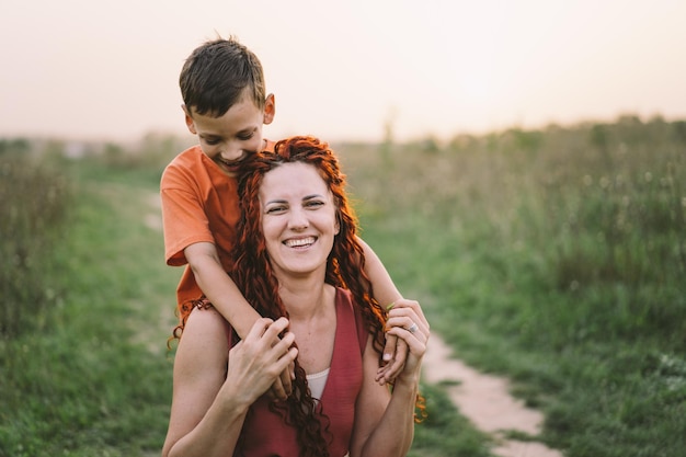 Gelukkige moeder die plezier heeft met haar zoon buiten Familie en liefde concept Het concept van moederdagrelaties met zorg en liefde voor adolescenten