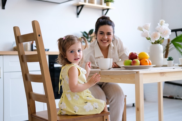 Foto gelukkige moeder en dochter die ontbijt hebben thuis