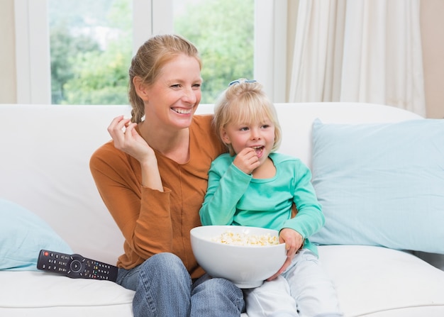 Gelukkige moeder en dochter die op TV letten