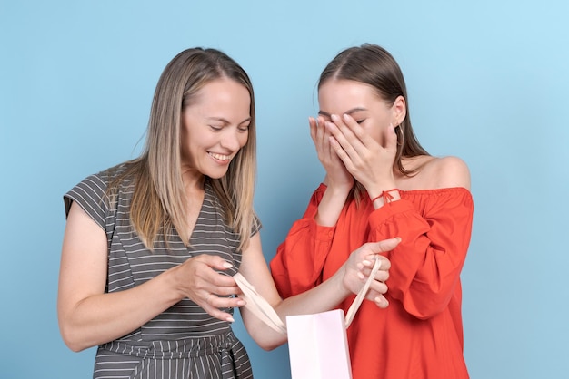 Gelukkige moeder en dochter kijken naar leuk winkelen, dochter gebaart