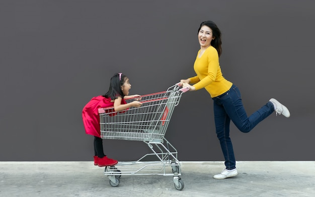 Gelukkige moeder en kind gaan samen naar het winkelwagentje