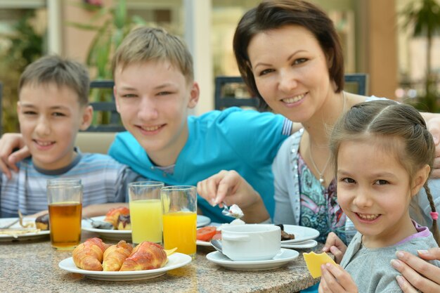 Gelukkige moeder en kinderen bij het ontbijt op tropisch resort