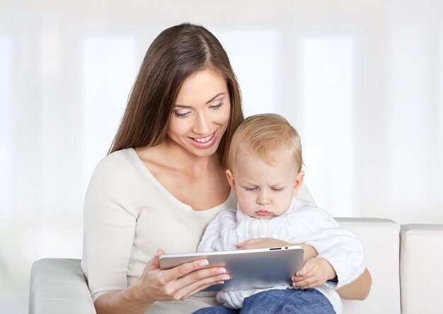 Gelukkige moeder en schattige baby met tablet-pc