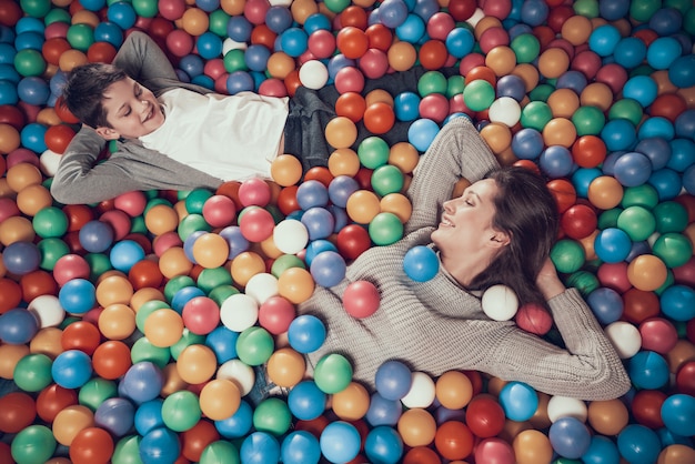 Gelukkige moeder en zoon in pool met ballen