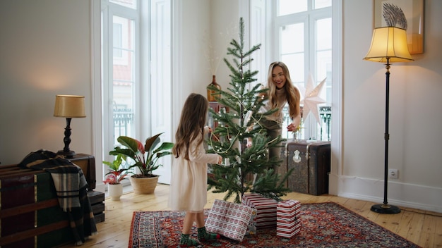 Gelukkige moeder kiekeboe dochter spelen op vakantie kamer Meisje springen met plezier