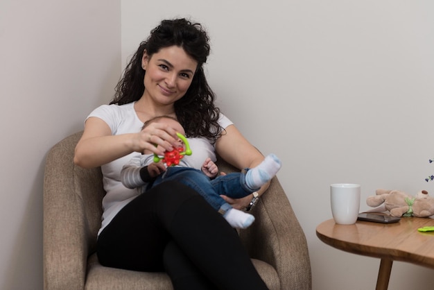 Gelukkige moeder met baby in de woonkamer