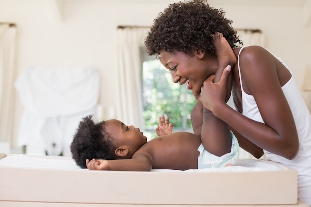 Gelukkige moeder met babymeisje op de commode