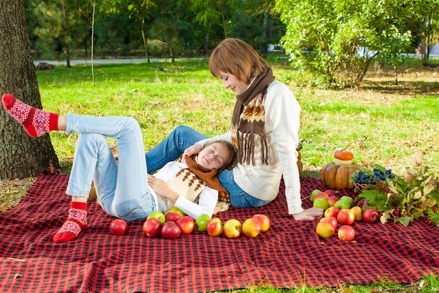 Gelukkige moeder met dochtertje in herfstpark