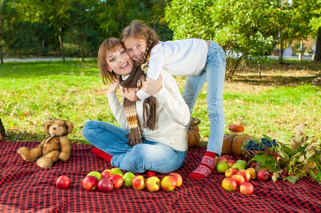 Gelukkige moeder met dochtertje in herfstpark