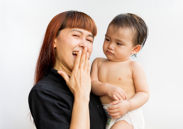 Foto gelukkige moeder met haar baby op geïsoleerde witte achtergrond moeder en zoon zwaaien handen kijken camera vrolijk lachend vrolijk jonge aantrekkelijke gelukkige moeder lachend knuffelen kijken naar haar kleine baby