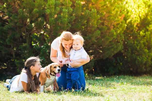 Gelukkige moeder met haar dochter, zoontje en beagle hond voor een wandeling