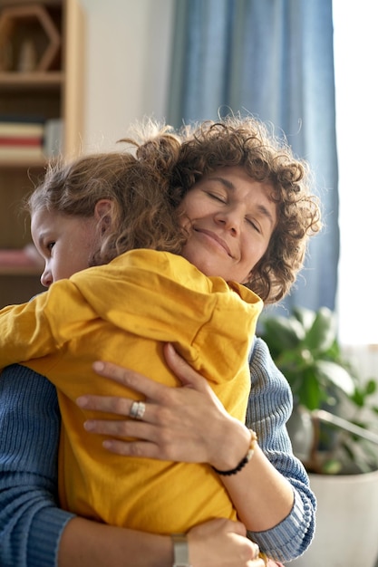 Gelukkige moeder omhelst haar zoon en toont hem al haar liefde