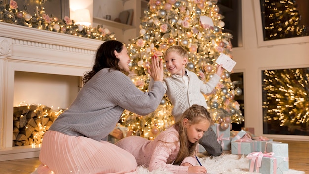 Gelukkige moeder tijd doorbrengen met haar kinderen op Kerstmis