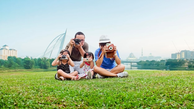 Gelukkige moeder vader en dochter nemen foto in het park