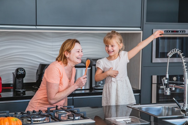 Gelukkige Moederdag! Kind dochter en moeder koken en plezier hebben in de keuken thuis. Familie vakantie en samenzijn.