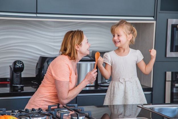 Gelukkige Moederdag! Kind dochter en moeder koken en plezier hebben in de keuken thuis. Familie vakantie en samenzijn.