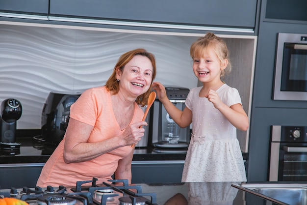 Gelukkige Moederdag! Kind dochter en moeder koken en plezier hebben in de keuken thuis. Familie vakantie en samenzijn.