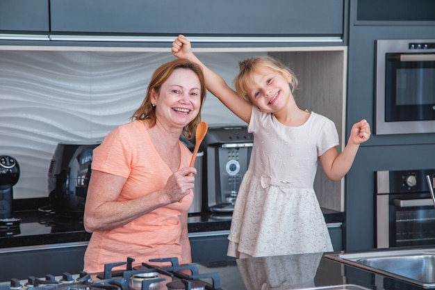 Gelukkige Moederdag! Kind dochter en moeder koken en plezier hebben in de keuken thuis. Familie vakantie en samenzijn.