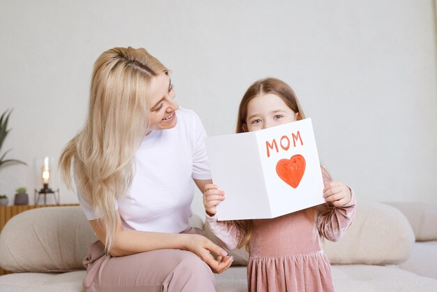 Gelukkige moederdag Kinddochter feliciteert haar moeder en geeft haar ansichtkaart