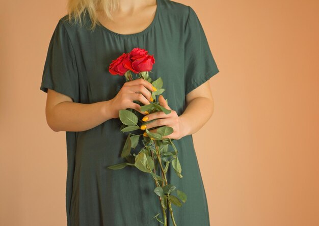 Gelukkige mooie jonge vrouw met bloemen Jong glimlachend blond meisje dat van een boeket bloemen geniet