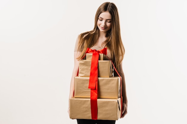 Gelukkige mooie jonge vrouw met geschenkdozen met heden op witte achtergrond Evenement vieren en cadeau ontvangen op verjaardag of andere feestdag