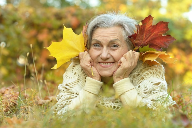 Gelukkige mooie senior vrouw in het herfstpark