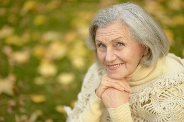 Gelukkige mooie senior vrouw in het herfstpark