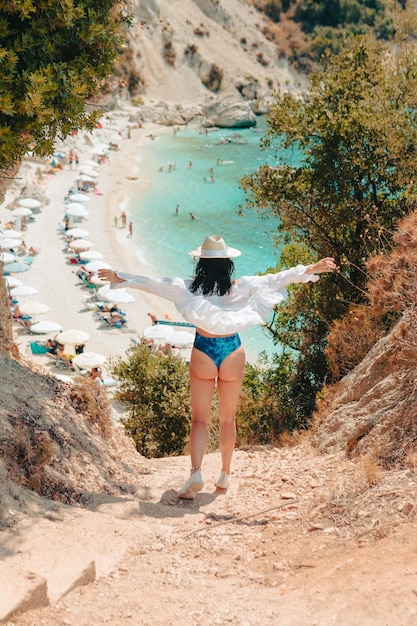 Gelukkige mooie vrouw die naar het zeestrand gaat