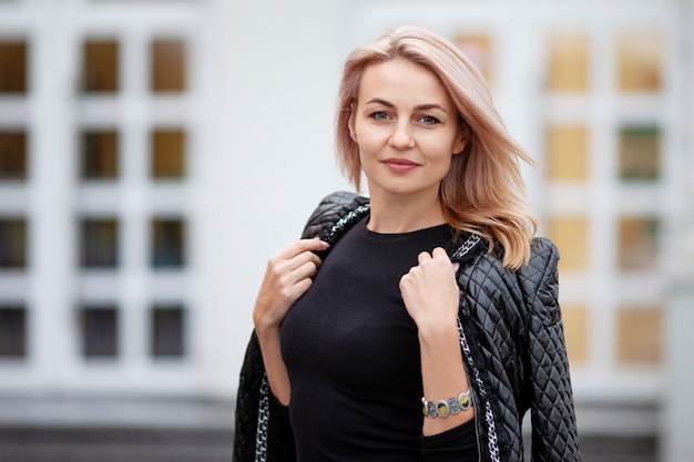 Gelukkige mooie vrouw die pret op stadsstraat heeft. Mode vrouw loopt op straat.