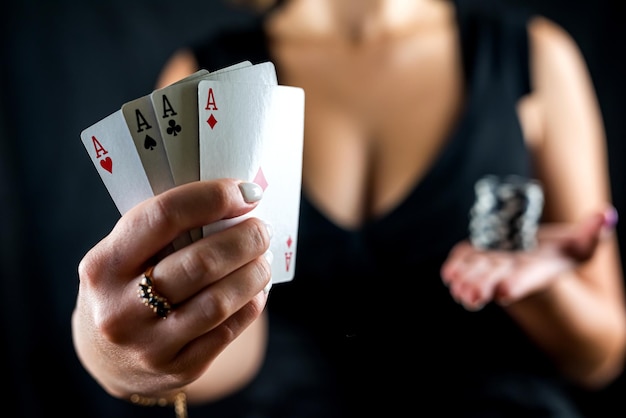 Foto gelukkige mooie vrouw in een verleidelijke jurk speelt poker aan de casinotafel