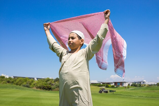 Gelukkige moslimfamilie op weide met sjaal