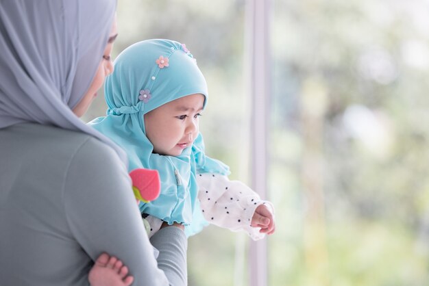 Gelukkige moslimmoeder die een mooie kleine baby houdt