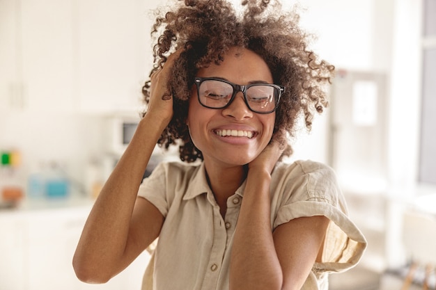 Gelukkige multi-etnische vrouw die een bril draagt en geniet van een zonnige dag