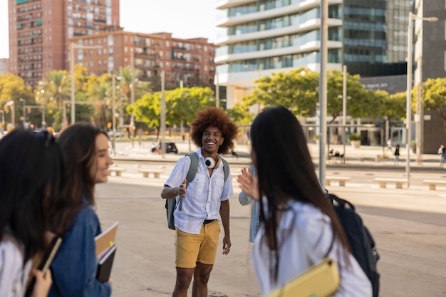 Gelukkige multiraciale groep vrienden die door de straten van de stad lopen Vrolijke jonge mensen die samen rondhangen studenten Focus op Afro-Amerikaanse man