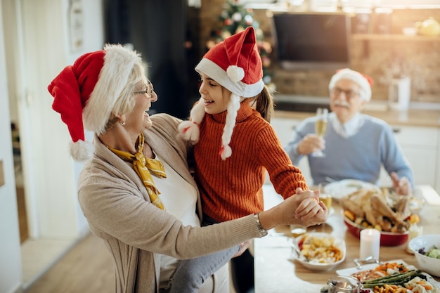 Gelukkige oma en kleindochter dansen op eerste kerstdag thuis