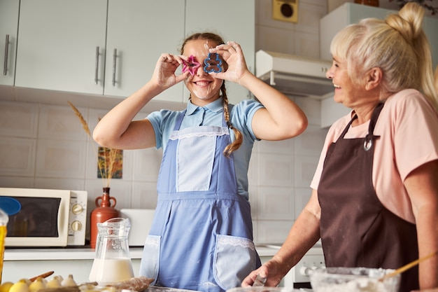 Gelukkige oma en lieve kleindochter die plezier heeft met koken