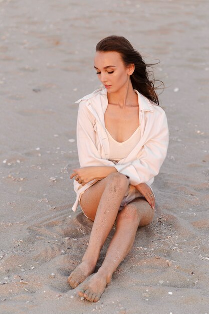 Gelukkige onbezorgde vrouw op het strand dat van de zomer geniet