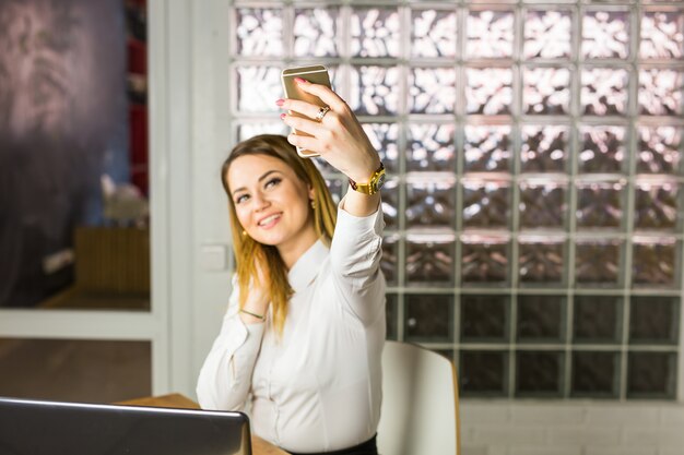 Gelukkige onderneemster die selfie foto in bureau maken