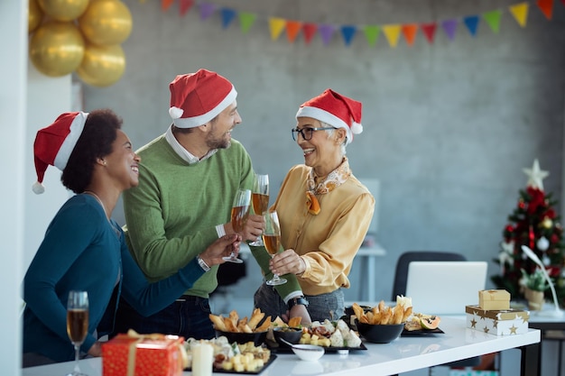 Foto gelukkige ondernemers die met champagne proosten terwijl ze het kerstfeest op kantoor vieren