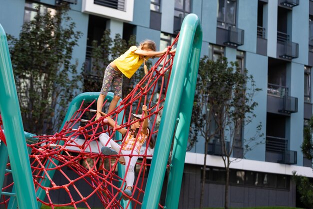 Gelukkige opgewekte kinderen die pret hebben samen op speelplaats