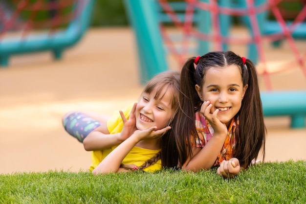 Gelukkige opgewekte kinderen die pret hebben samen op speelplaats