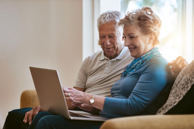 Gelukkige oudere echtpaar bank en discussie met laptop voor het browsen van online winkelen of financiën thuis Oudere man en vrouw bespreken pensioen of pensioenfonds op de computer in de woonkamer thuis