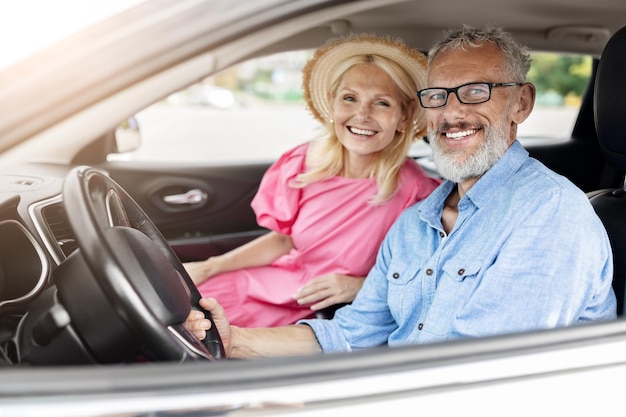 Foto gelukkige oudere echtpaar in de auto met het raam naar beneden