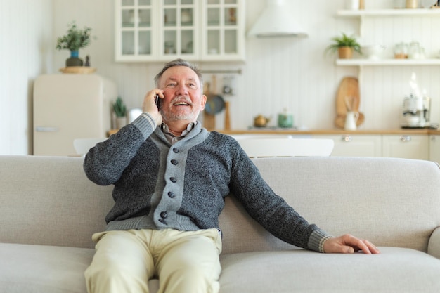 Gelukkige oudere man van middelbare leeftijd die op zijn smartphone praat met familie vrienden oudere volwassen grootvader met